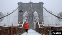 A man runs over the Brooklyn Bridge during morning snow in Manhattan, New York City, Dec. 17, 2016. 