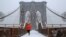 A man runs over the Brooklyn Bridge during morning snow in Manhattan, New York City, Dec. 17, 2016. 