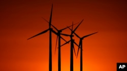 FILE - Wind turbines are silhouetted against the setting sun at the Spearville Wind Farm, Sept. 29, 2024, near Spearville, Kansas.