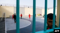 Des détenus de la prison d'Oukacha aperçus depuis une grille lors d’un mini tournoi de football organisé par des prisonniers africains pour coïncider avec la compétition CHAN-2018, à Casablanca, Maroc, 1er février 2018.