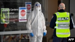 Medical workers speak at the entrance of the Epping Gardens aged care facility in the Melbourne suburb of Epping on July 29, 2020, as the city battles fresh outbreaks of the COVID-19 coronavirus. 