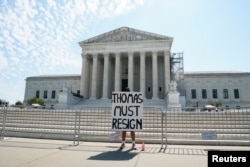 Una mujer sostiene un cartel pidiendo la renuncia del juez de la Corte Suprema de EEUU Clarence Thomas afuera de la Corte Suprema, antes de que se emitiera el fallo en Washington, Estados Unidos, el 14 de junio de 2024. REUTERS/Elizabeth Frantz