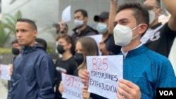 Un joven sostiene un cartel durante una concentración en la sede el Programa de las Naciones Unidas para el Desarrollo en Caracas antes de la llegada del fiscal de la CPI, Karim Khan. Octubre 29, 2021. Foto: Adriana Nuñez Rabascall VOA.