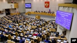 FILE - Russian lawmakers are seen during a vote at the State Duma, the Lower House of the Russian Parliament, in Moscow, Russia, May 8, 2018.