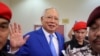 FILE - Former Malaysian Prime Minister Najib Razak waves to photographers as the jailed politician leaves the court after court proceedings in Kuala Lumpur, Malaysia, Jan. 19, 2024. 