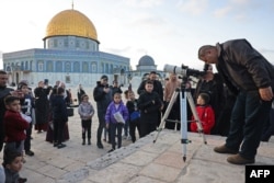 Seorang pria menggunakan teleskop untuk mengamati hilal di kompleks masjid Al-Aqsa di Kota Tua Yerusalem pada 10 Maret 2024. (Foto : AFP)
