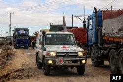 FILE —Vehicles of the International Red Cross carrying aid cross into Rafah in the southern Gaza Strip on November 15, 2023, amid the ongoing battles between Israel and the Palestinian group Hamas.