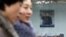 Women walk past a picture of the new North Korean leader Kim Jong-Un outside the North Korean Embassy in Beijing December 12, 2012.