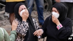 Warga tampak menangis saat gedung apartemen tempat mereka tinggal hancur akibat serangan Israel ke Beirut, Lebanon, pada 11 Oktober 2024. (Foto: AP/Hassan Ammar)