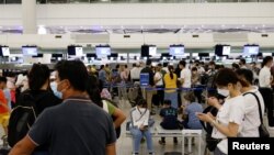 Des passagers font la queue au comptoir British Airways de l'aéroport international de Hong Kong à Hong Kong, Chine, le 30 juin 2021. REUTERS/Tyrone Si