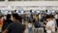 Des passagers font la queue au comptoir British Airways de l'aéroport international de Hong Kong à Hong Kong, Chine, le 30 juin 2021. REUTERS/Tyrone Si