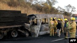 Firefighters work at the scene of an accident involving a tourist van and a cargo truck on the Lagos de Moreno highway in Zapotlanejo, Jalisco state, Mexico, Dec. 18, 2019.