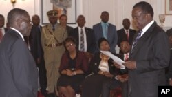 FILE: Emmerson Mnangagwa, right, is sworn in as Vice President by Zimbabwean President Robert Mugabe at State House in Harare, Friday, Dec, 12, 2014. Mnangagwa was sworn in following a cabinet reshuffle that saw former deputy President Joice Mujuru dismissed from her post over allegations that she plotted to remove Zimbabwean President Robert Mugabe from power.( AP Photo/Tsvangirayi Mukwazhi)