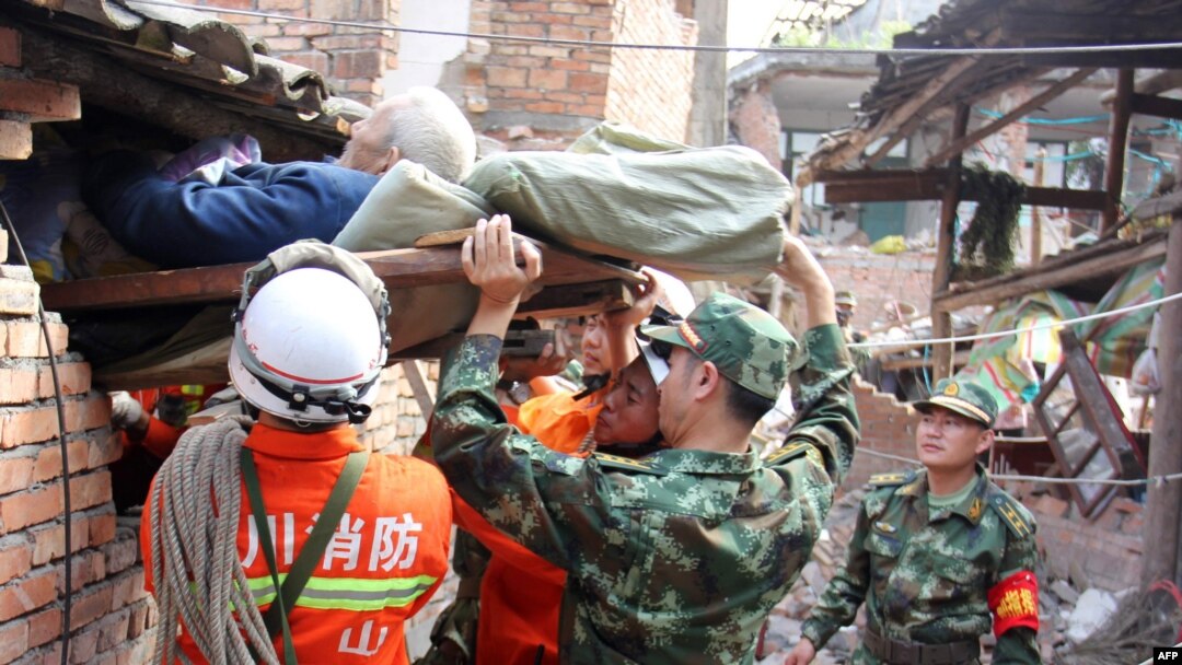 Regu penolong membantu seorang lansia keluar dari rumahnya yang hancur akibat gempa berkekuatan 7.0 yang mengguncang wilayah Qingren, Lushan di propinsi Sichuan, Chian (20/4).