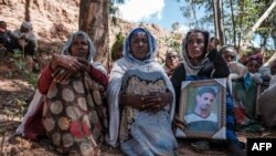 FILE - People mourn the victims of a massacre allegedly perpetrated by Eritrean soldiers, in the village of Dengolat, north of Mekele, the capital of Ethiopia's Tigray region, Feb. 26, 2021.