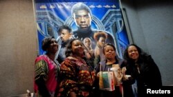 Sekelompok perempuan berfoto di depan poster "Black Panther" dalam penayangan perdana di bioskop AMC Magic Johnson Harlem 9, di Manhattan, New York, 15 Februari 2018.