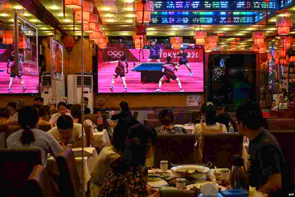 중국 베이징의 한 식당에 중국과 일본의 2020 도쿄 올림픽 혼합복식 탁구 대결 경기가 중계되고 있다. 
