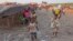 A child (r) carries food stuff on her head that she and other family children try to sell  by walking from market area to market area in Kinshasa, Democratic Republic of Congo, May 28, 2014.