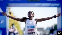 FILE - Ethiopia's Tigist Assefa celebrates as she crosses the finish line to win the women's division of the Berlin Marathon in world record time in Berlin, Germany, Sunday, Sept. 24, 2023. (AP Photo/Markus Schreiber)
