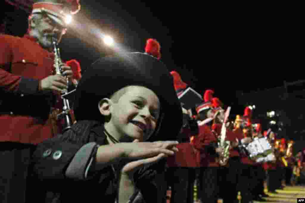 A kid dances as member of a municipal band perform during a concert during the lighting of a Christmas tree in the Greek capital's main Syntagma Square, central Athens, on Friday, Dec. 9, 2011. Athens municipal officials have said this year's Christmas fe