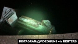 The statue of Christopher Columbus is seen in a lake after it was pulled down by protesters in Richmond, Virginia, June 9, 2020, in this picture obtained from social, June 9, 2020. (Instagram/@Videoguns)