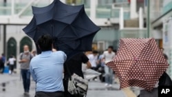 Un hombre pasa problemas para mantener el paraguas abierto a causa de los fuertes vientos del tifón Ampil, en una calle de Tokio, Japón, el 16 de agosto de 2024.