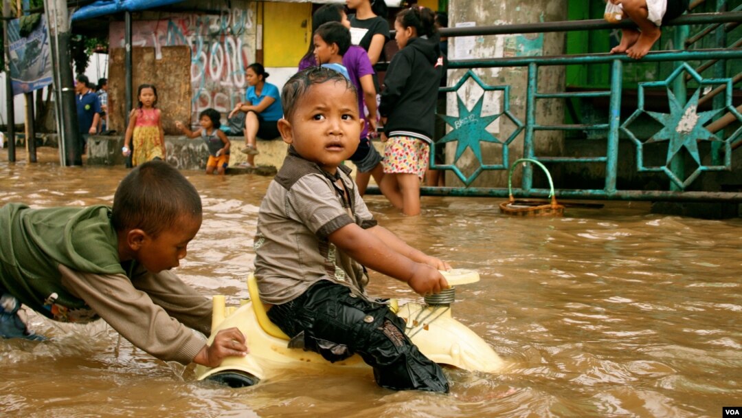 Children play in flood waters after torrential rains in Kampung Melayu, South Jakarta, Indonesia, January 17, 2013. (K. Lamb/VOA)