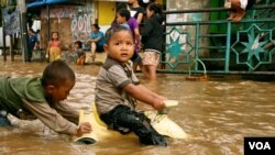 Children play in flood waters after torrential rains in Kampung Melayu, South Jakarta, Indonesia, January 17, 2013. (K. Lamb/VOA)