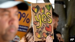 A woman holds a hand-made "Yes" sign as supporters gather at the Redfern Community Centre in Sydney, Oct. 9, 2023. Australians appear likely to reject the creation of an advocate for the Indigenous population in a referendum outcome that some see as a victory for racism.