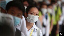 In this photo taken on Jan. 28, 2020, Cambodian students line up to sanitize their hands to avoid the contact of coronavirus before their morning class at a high school in Phnom Penh, Cambodia.