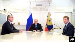 Russian President Vladimir Putin, center, watches the opening ceremony of natural gas pipeline from Russia to Crimea during a live video link from the Kremlin in Moscow, Dec. 27, 2016.