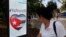 A woman passes by a screen displaying images promoting the vote for "yes" for the constitutional referendum, in Havana, Cuba, Feb. 5, 2019. 