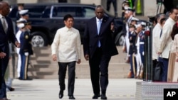Menteri Pertahanan AS Lloyd Austin (kanan) menyambut kedatangan Presiden Filipina Ferdinand Marcos Jr. ke Pentagon hari Rabu (3/5). 