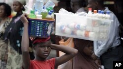 O comércio ambulante é a via por excelência dos adoslecentes nigerianos no seu quotidiano. Esta fotografia retrata uma jovem vendendo água e gasosas na estação de autocarro na cidade de Lagos - Outubro 2012 