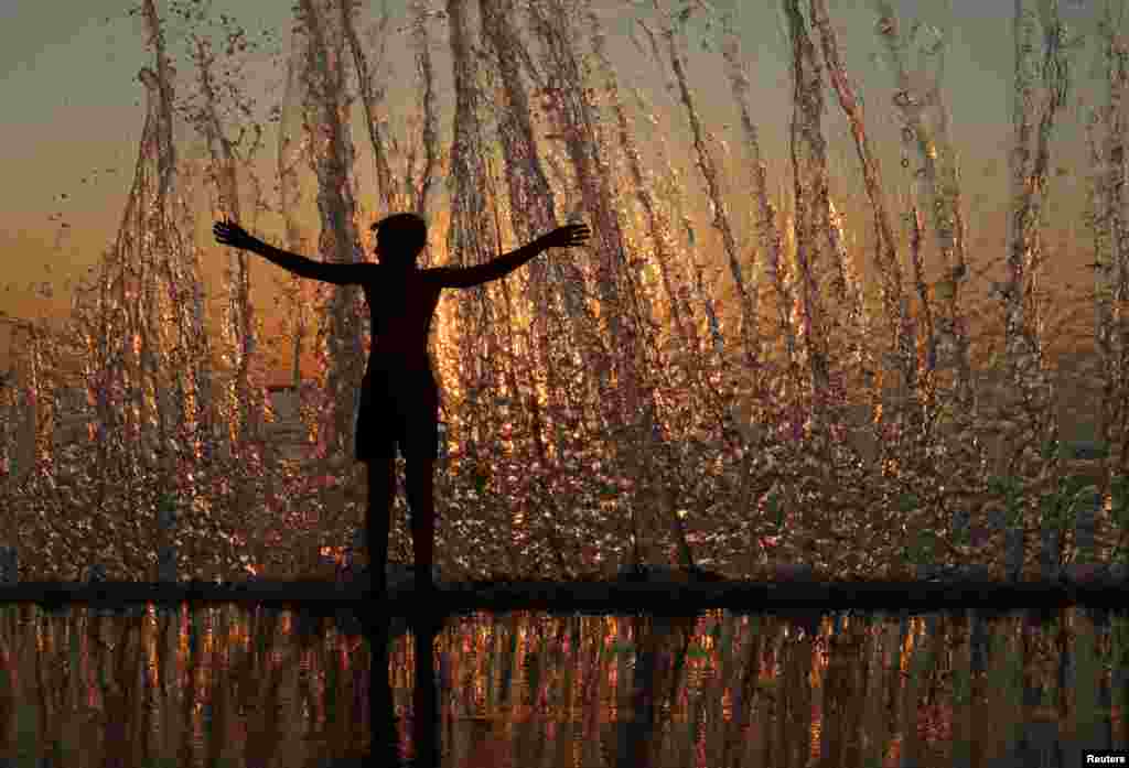 A boy enjoys the waves during sunset on an embankment in the Black Sea port of Sevastopol, Crimea, Aug. 9, 2017.