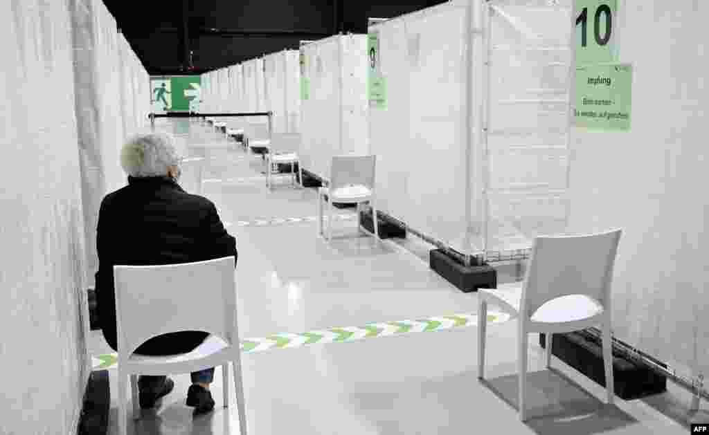 FILE - A woman waits to be called to receive the Pfizer-BioNTech COVID-19 vaccine at the regional coronavirus vaccination center in Ludwigsburg, southern Germany, Jan. 22, 2021.