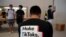 FILE - A man wearing a shirt promoting TikTok is seen at an Apple store in Beijing, China, July 17, 2020.