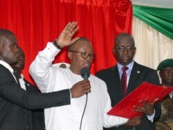 FILE - Guinea-Bissau's newly elected president Umaro Cissoko Embalo raises his arm during his swearing-in ceremony in Bissau, Feb. 27, 2020.