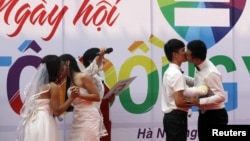 Các cặp vợ chồng đồng tính Lê Thùy Linh và Trần Ngọc Diễm Hằng cùng Hồ Hải Thịnh và Phạm Tiến Dũng hôn nhau tại lễ cưới tại Hà Nội, ngày 27/10/2013.