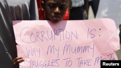 Un garçon tient une pancarte lors d'un rassemblement en soutien à la campagne anti-corruption du président Muhammadu Buhari, à Abuja, au Nigeria, le 17 août 2015.