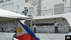 American crew members stand on the deck of the decommissioned U.S. Coast Guard cutter Dallas in North Charleston S.C., on May 22, 2012, during a ceremony in which it was transferred to the Philippine Navy.