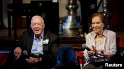 Mantan Presiden AS Jimmy Carter bersama mantan ibu negara Rosalynn, saat merayakan ulang tahun ke-75 pernikahan mereka di Plains, Georgia, 10 Juli 2021. (John Bazemore/Pool via REUTERS)