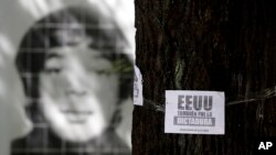 Foto de un desaparecido durante la última dictadura militar de Argentina detrás de un panfleto en un árbol que acusa a Estados Unidos de apoyar a ese régimen y protesta contra la visita del presidente Obama la próxima semana.