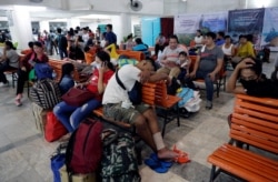 Passengers wait for their ride at the Cubao bus terminal in metropolitan Manila, Philippines on Friday, March 13, 2020.