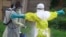 In this photo taken Sept. 9, 2018, a health worker sprays disinfectant on his colleague after working at an Ebola treatment centre in Beni, Eastern Congo.