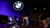 FILE - Visitors look at vehicles at the BMW booth at the Beijing International Automotive Exhibition, or Auto China 2024, in Beijing, April 25, 2024. The company has cut its profit margin forecast in part because of sluggish demand in China.