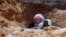 This citizen journalism image provided by ENN shows a Syrian rebel in a trench, in Idlib province, northern Syria, June 12, 2013. 