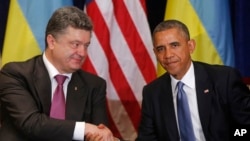 U.S. President Barack Obama, right, shakes hands with Ukraine president-elect Petro Poroshenko in Warsaw, Poland, June 4, 2014.