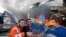 Des pompiers palestiniens essayent d'éteindre le feu dans une usine d'éponges après des tirs d'obus israéliens dans le nord de la bande de Gaza le 17 mai 2021. 