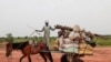 FILE - A Chadian cart owner transports belongings of Sudanese people who fled the conflict in Sudan's Darfur region, while crossing the border between Sudan and Chad in Adre, Chad August 4, 2023.